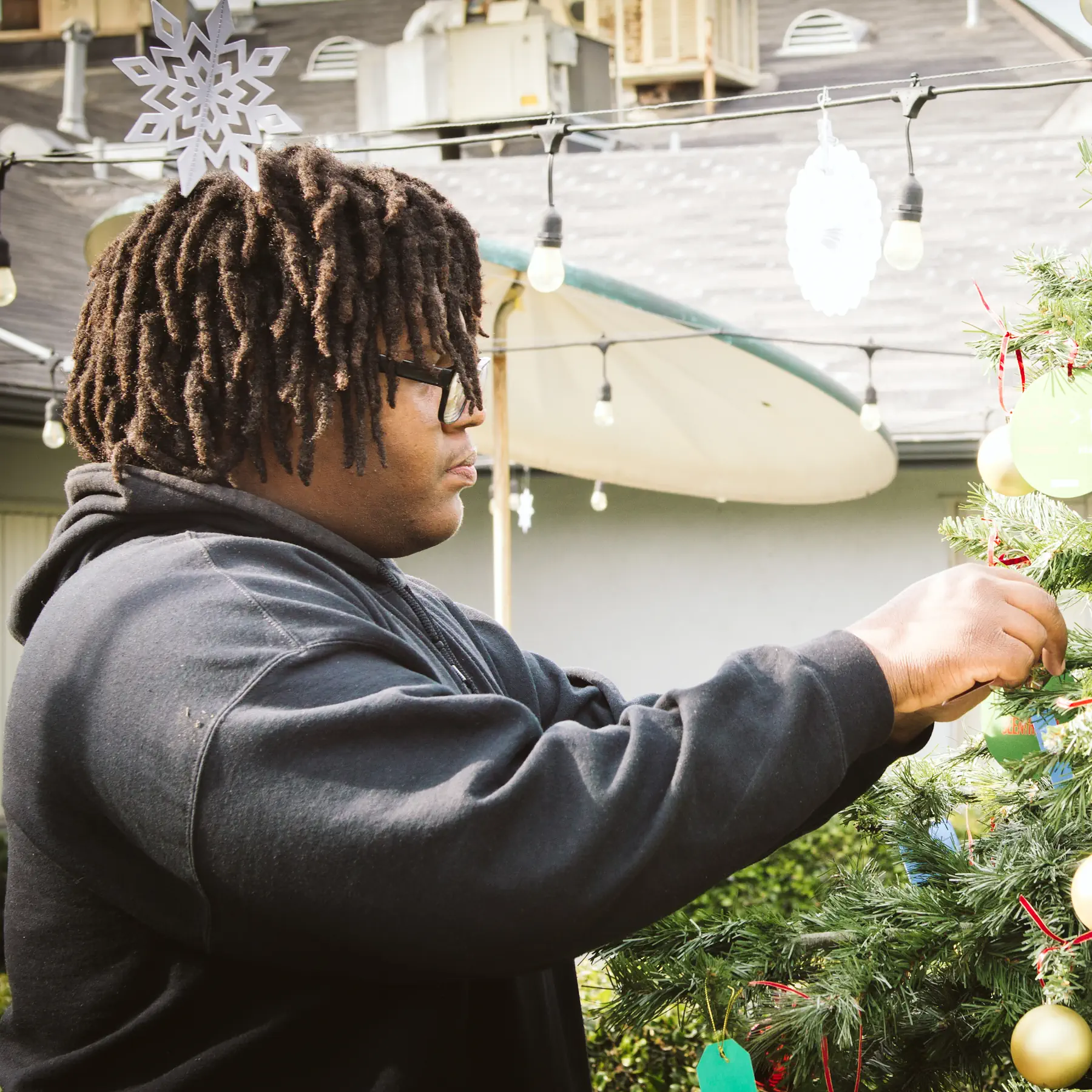 Man hanging ornaments on Christmas tree